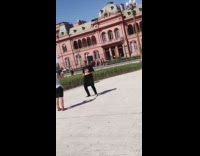 kid dances pink palace building