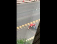 Guy lays down next to dead rat on sidewalk