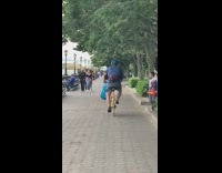 Man riding bike with a bird on shoulder