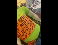 Guy reads funny orange sign on green mannequin 