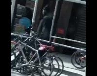 man walking in all black robe coat pointy hat street