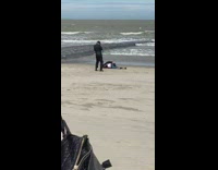 Woman black jacket hoodie lay down beach 