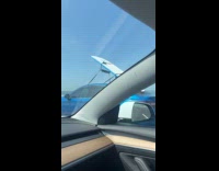 Car on highway with surfboard raised upward