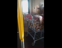 Guy sits on shopping cart filled with beer bottles on subway train