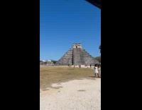 Women white dress poses with pyramid behind