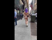 Man in purple wig and thong walking on street