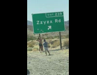 Guy flex muscles large green sign Zzyzx