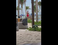 Guy photographs lady laying on back beach 