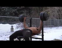 Guy lifts weights while friends throw plastic eggs