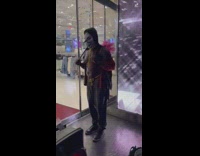 Shirtless man wearing clown mask doing workout as street performance