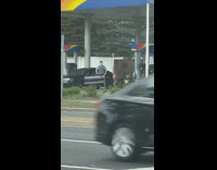 Guy go shirtless beside car gas station