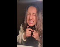 Woman kissing black cat and it meows