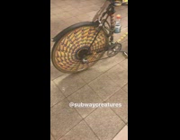 Man in yellow wrapper jacket and bike in subway station turnstiles