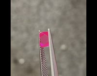 Red crystal jewel stone in between tweezers 