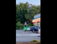 Collab WINY - Woman green sacks walk with stilts street