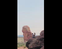 Couple sit pose brown rock green dress 