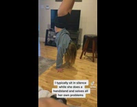 Girl in middle of room blue hoodie jacket handstand 