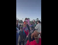 Group of people holding up their brown weiner dogs 