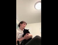 Woman trims claws of her two cats