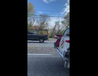 Ghostbusters car drives on the road beside the car of filmer
