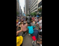 Collab winy - People kneel worship large black statue street