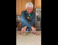 Old man separate Christmas balls by color