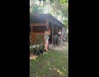 White shirt girl sits barrel black dog