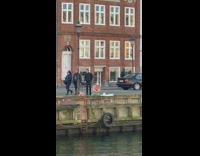 Woman crouches to take photo of object