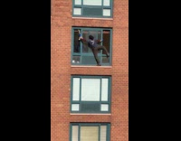 Man cleaning holds window with no harness