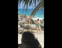 Shirtless man fly pose on the beach rock