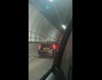 Two women sit outside car window tunnel