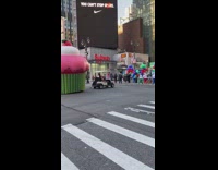 White golf cart drags large inflatable cupcake 