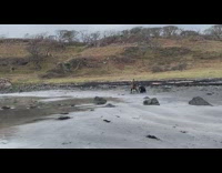 Woman carries a stone with a rock between her legs