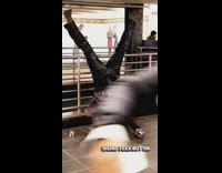 man brown jacket striped shirt head stand