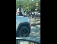 Man holds makeshift stick with cup for money