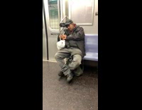 Man uses cell phone holder on rail and falls asleep while watching movie on subway train