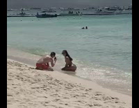 Girl wearing bikini poses on beach 