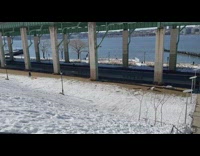 Guy skis down hill by river snow