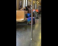 Guy on train scratches torso stomach 