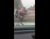 Guy rides motorcycle no hands one foot 