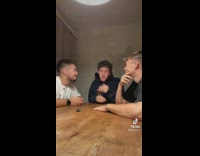 Three guys sitting at wood table discussion talking 