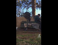White dog runs past camera as man lifts weights