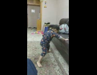 Little boy dancing to song while hanging onto couch