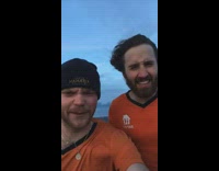 Two guys on mountain loud strong winds