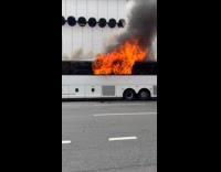 Bus parked on road with huge fire