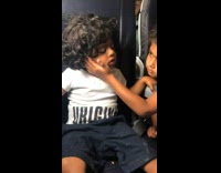 Little girl supported his asleep brother on the airplane chair