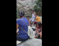 Woman in blue mermaid outfit poses at the waterfalls