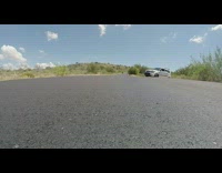 Guy going fast on skateboard down road falls