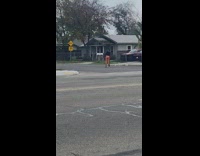 Little boy in red taking picture of woman street
