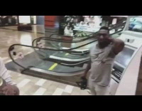 Guy uses VR set and gets slapped in the back of neck by friend going up the escalator